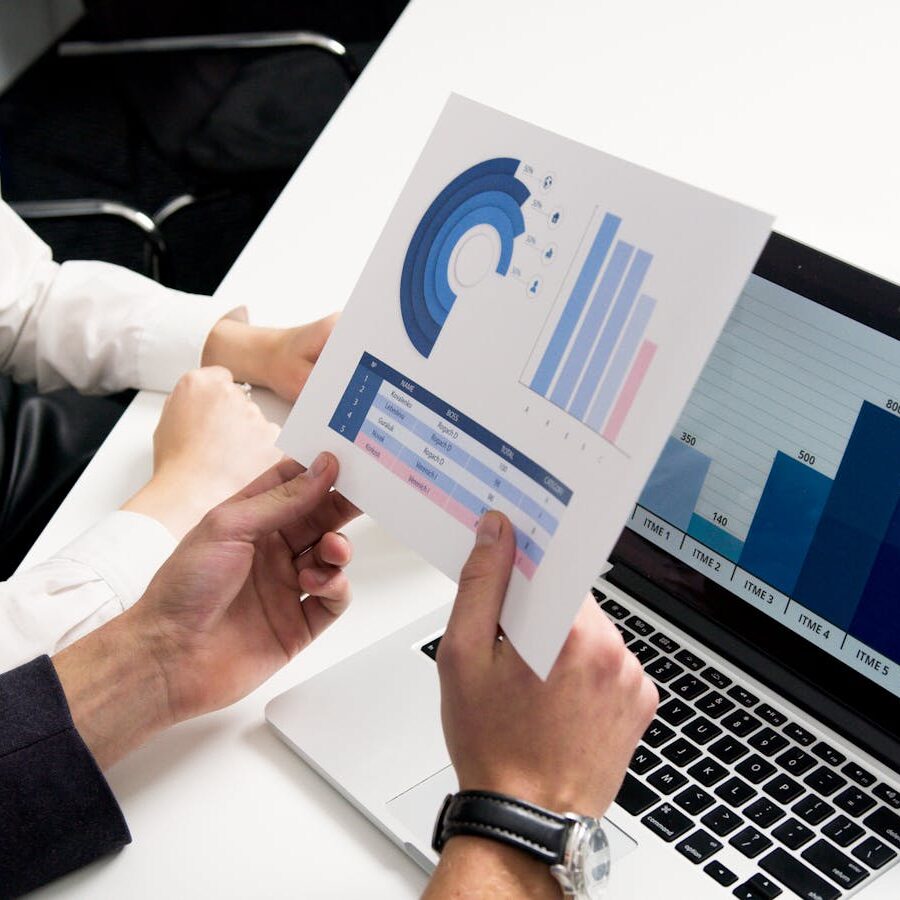 Business professionals discussing data charts and graphs in a modern office setting.